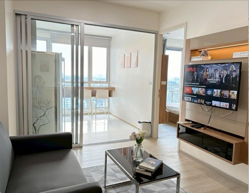 a living room with a couch and a tv at The Onnut Nest 1BR Sofa Bed Onnut BTS 50m in Bangkok