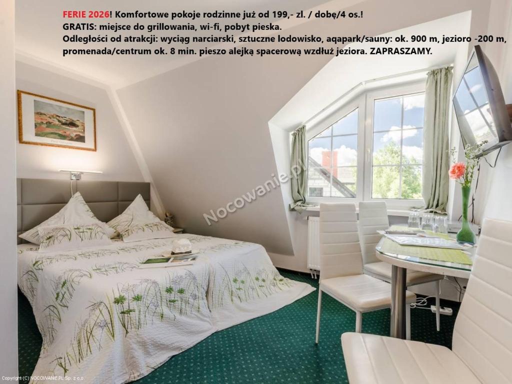 米科瓦伊基Willa Cyklada, grill, śniadania, jezioro,przystań,tawerna-200m, park linowy-400m, centrum,aquapark-900m的一间带床和桌子的白色卧室