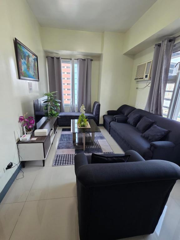 a living room with blue couches and a table at 8 Adriatico Condominium 1BR in Sampong