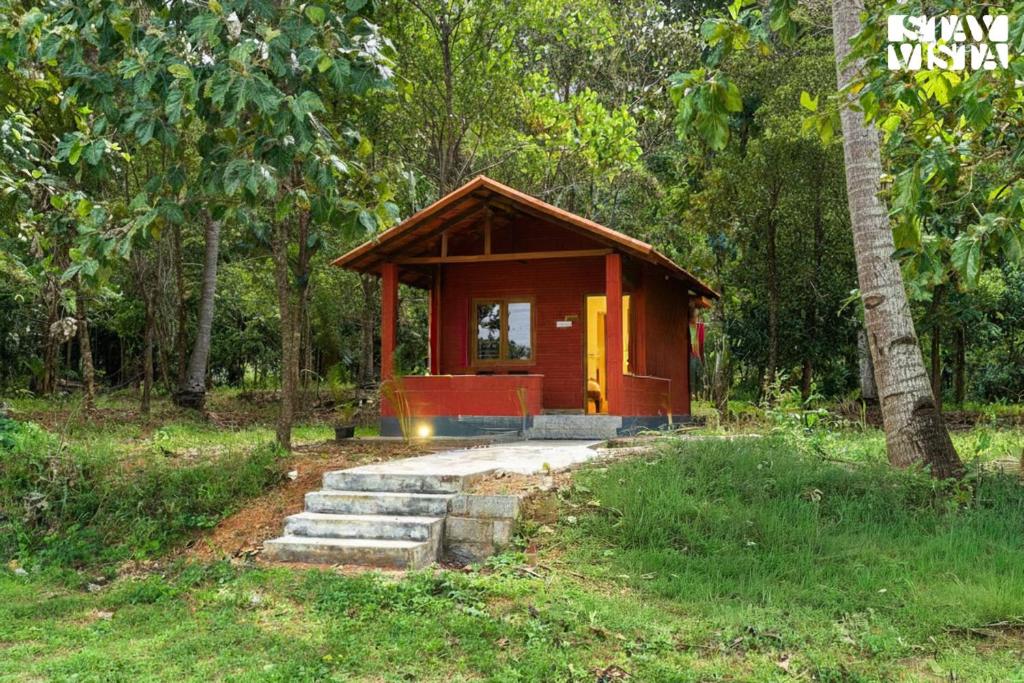 een kleine hut midden in een bos bij StayVista at Jims Farmstay with Pool, Pet-friendly in Halgūr