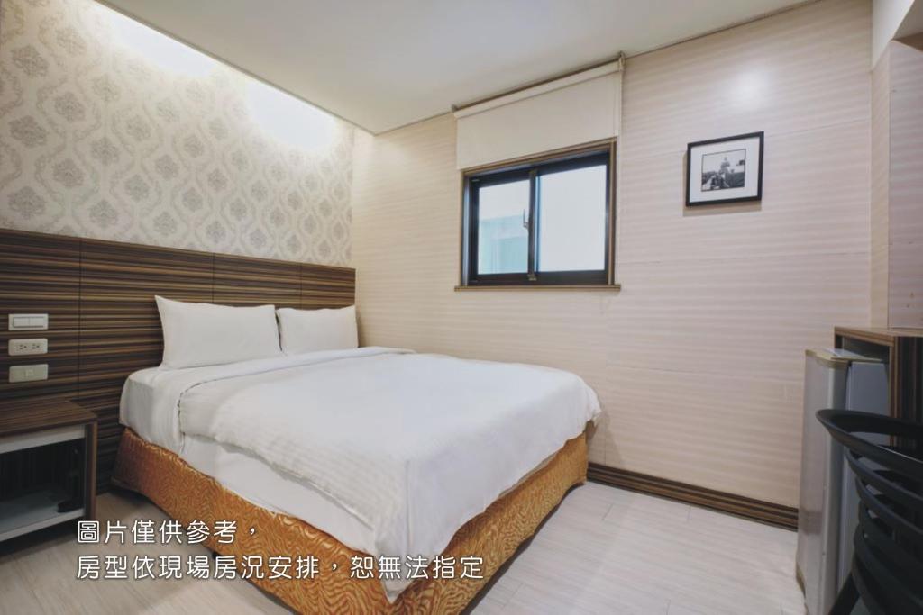 a bedroom with a large bed and a window at Wecan Hotel in Kaohsiung