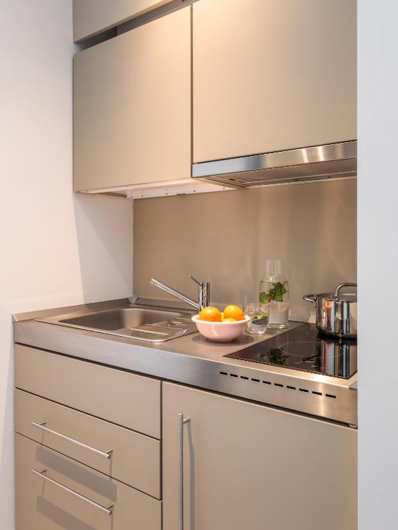 A compact kitchenette with a sink, induction hob and built-in storage.