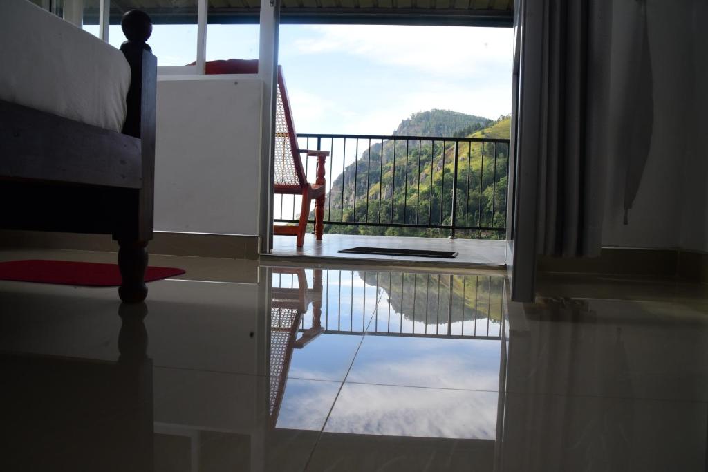 a room with a view of a balcony with a chair at Super View Home Stay in Ella