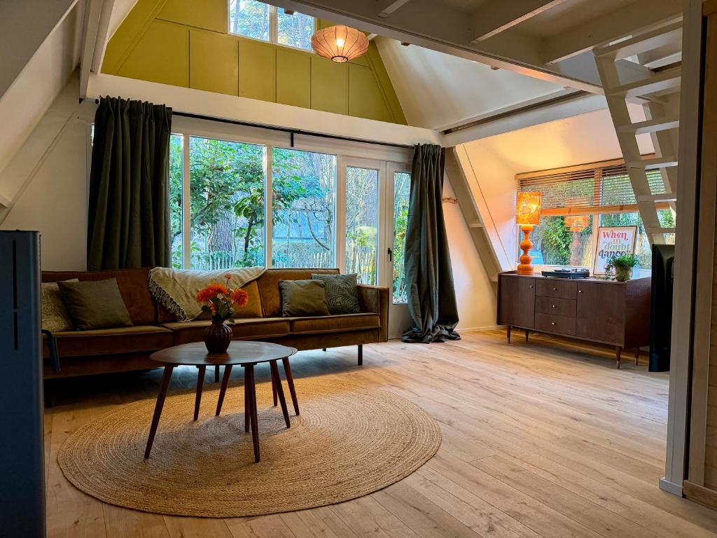 un soggiorno con un divano e un tavolo di Boshuisje Rekem - Nirvana a Lanaken