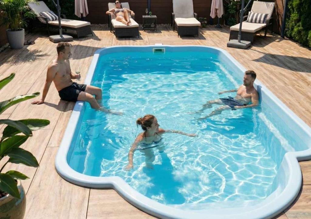eine Gruppe von drei Personen, die in einem Pool sitzen in der Unterkunft Wellness -Residenz Ehrhardt Urlaub mit Pool und Garten Ferienwohnung in Halberstadt in Halberstadt