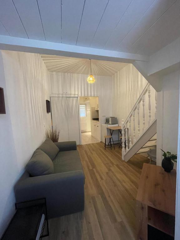 a living room with a couch and a staircase at Duplex charmant centre Joigny - 1 in Joigny