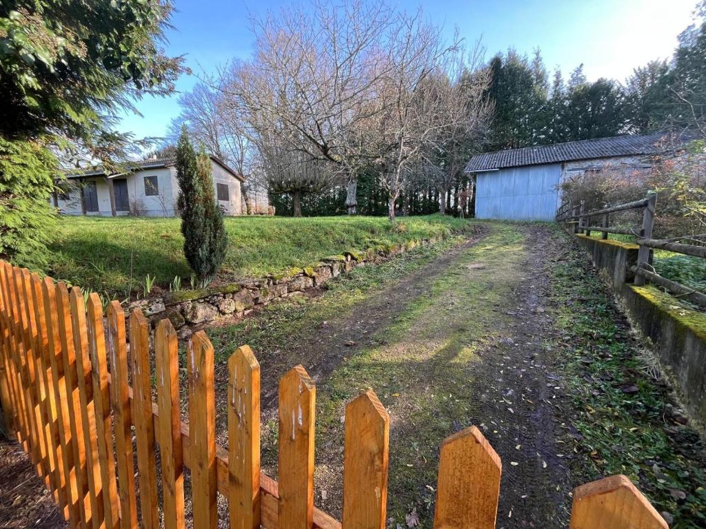 a wooden fence next to a dirt road at Maison David in Le Buis