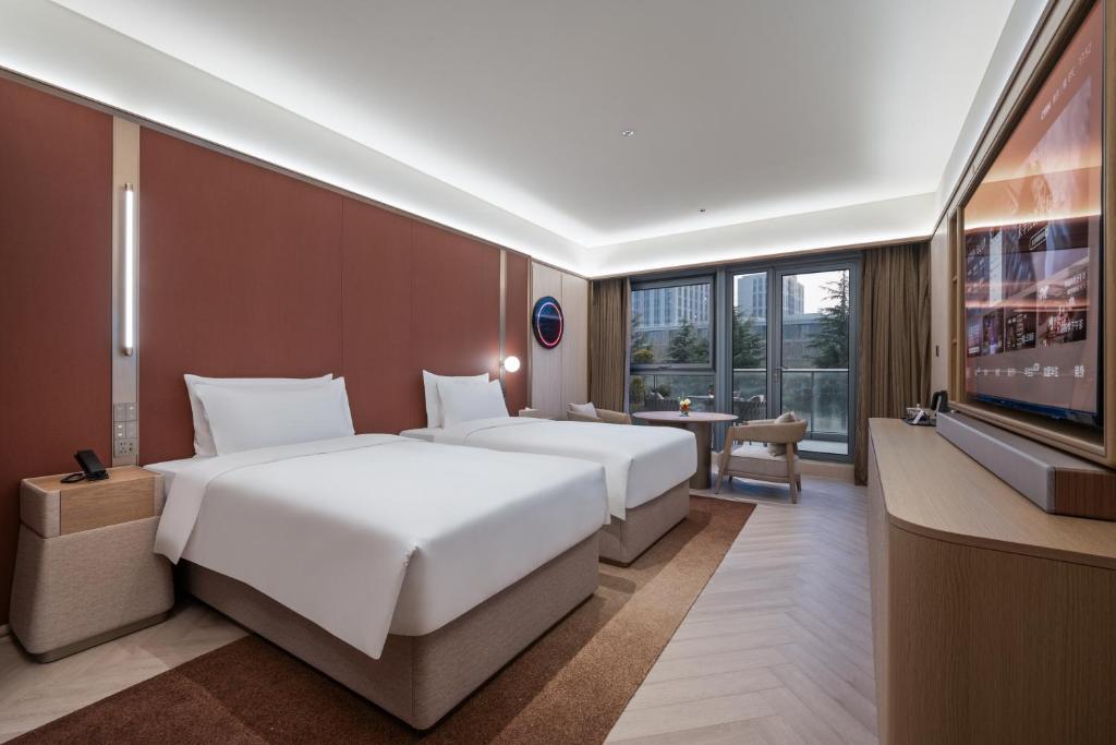 Postel nebo postele na pokoji v ubytování Orange Crystal Hotel Nanjing Jiangning Sasseur Southeast University