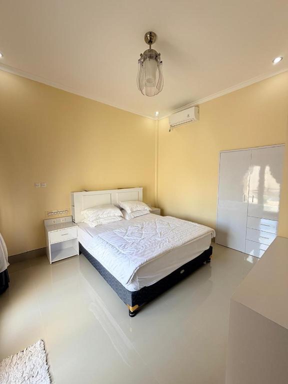 a bedroom with a bed and a chandelier at Amlana villa in Gili Trawangan