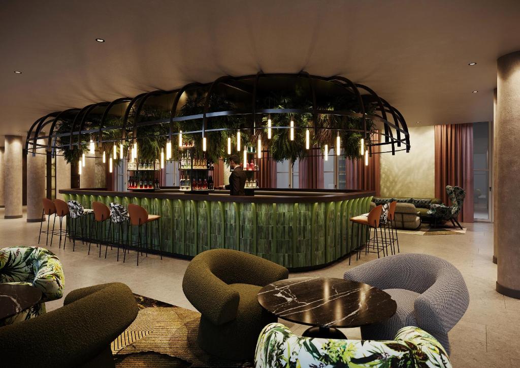 een lobby met een bar met stoelen en tafels bij Motel One Frankfurt-Hauptbahnhof in Frankfurt am Main