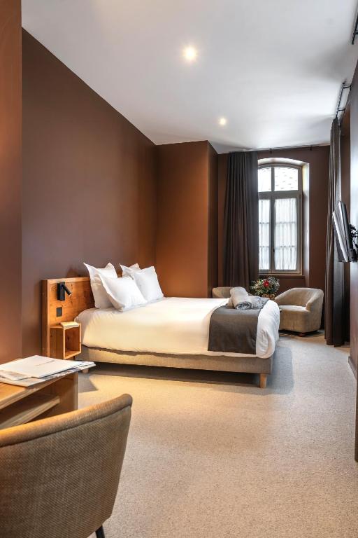 ein Schlafzimmer mit einem großen Bett, einem Tisch und Stühlen in der Unterkunft Maison Soyeuse in Briançon