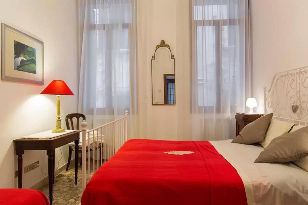 a bedroom with a bed with a red blanket on it at Apartment Minuetto in Venice