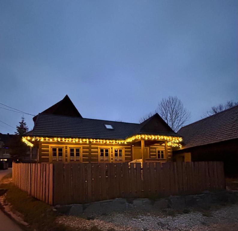 een houten huis met kerstverlichting erop bij Dom Sidzina in Sidzina