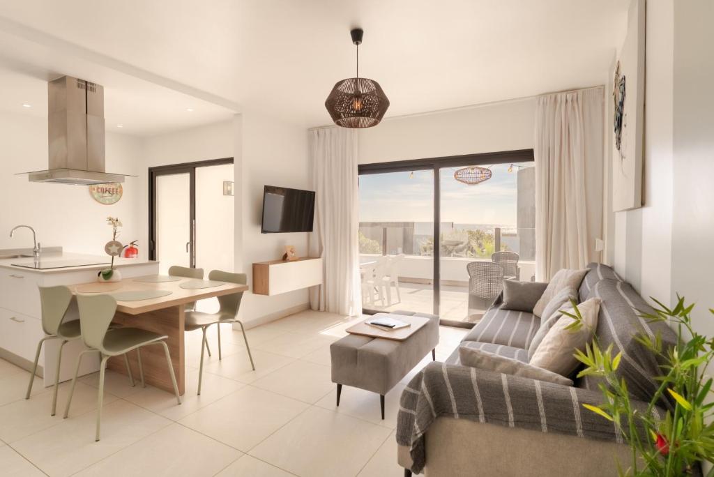 een woonkamer en keuken met een bank en een tafel bij Bimba's in Puerto del Carmen