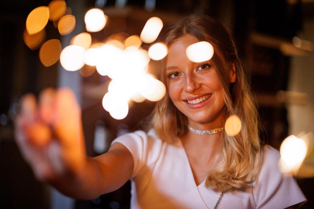 une femme prenant une photo avec son téléphone portable dans l'établissement Boutique Hotel Sunrose 7 - Gourmet & SPA, à Bohinj