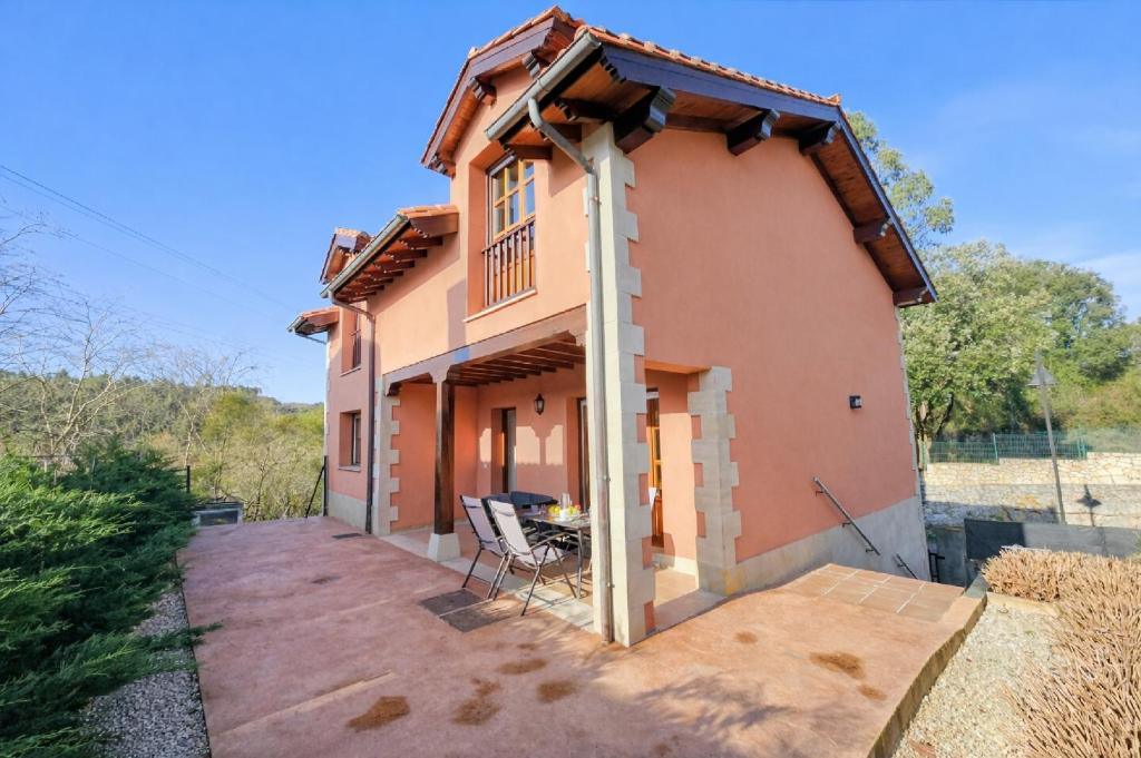 een huis met een veranda en een stoel op een patio bij Villa Freya - Casa con jardín cerca de la playa in Las Conchas