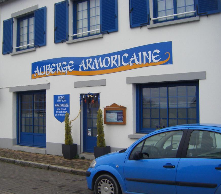 ein blaues Auto, das vor einem Gebäude parkt in der Unterkunft Auberge Armoricaine in Louisfert