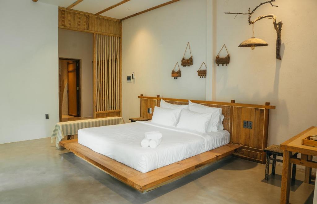 een slaapkamer met een bed met witte lakens en kussens bij Nong Lam Ecolodge in Linh Xuân Thôn