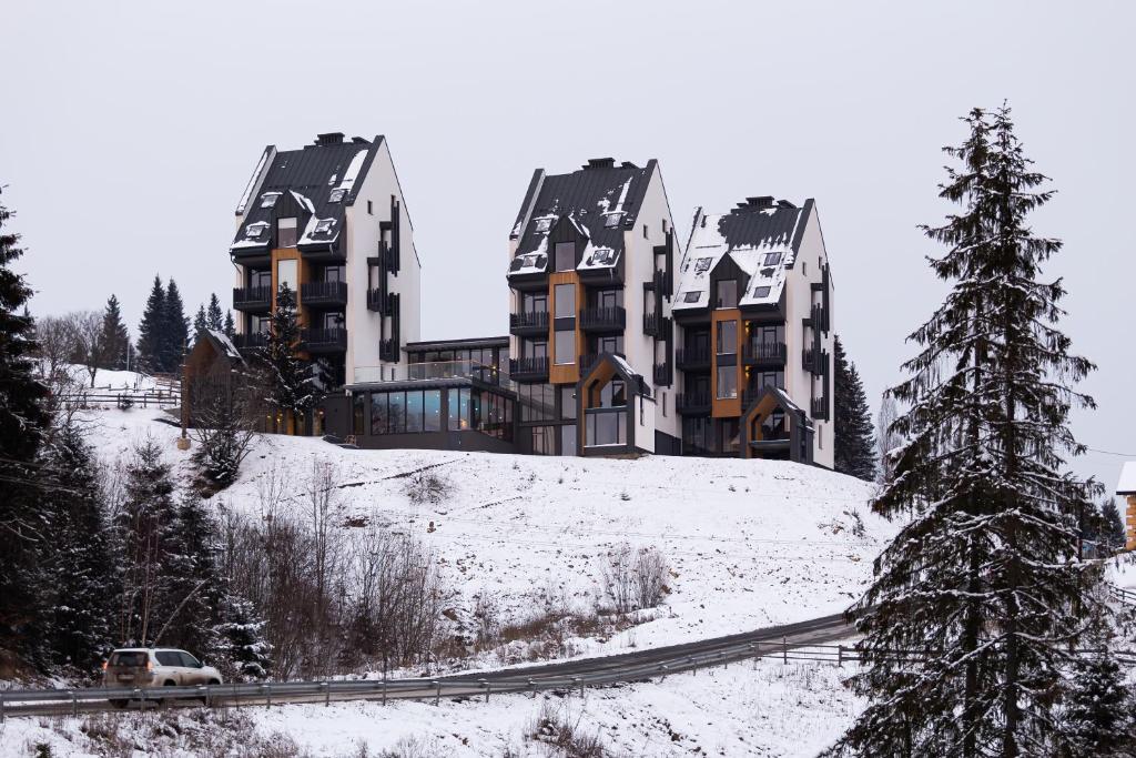 a building on top of a snow covered hill at ШПИЦІ Hotel & SPA in Bukovel