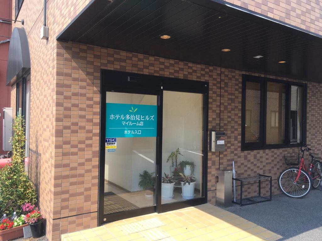 a store front of a brick building with a sign on it at Hotel Tajimi Hills Myroom in Tajimi