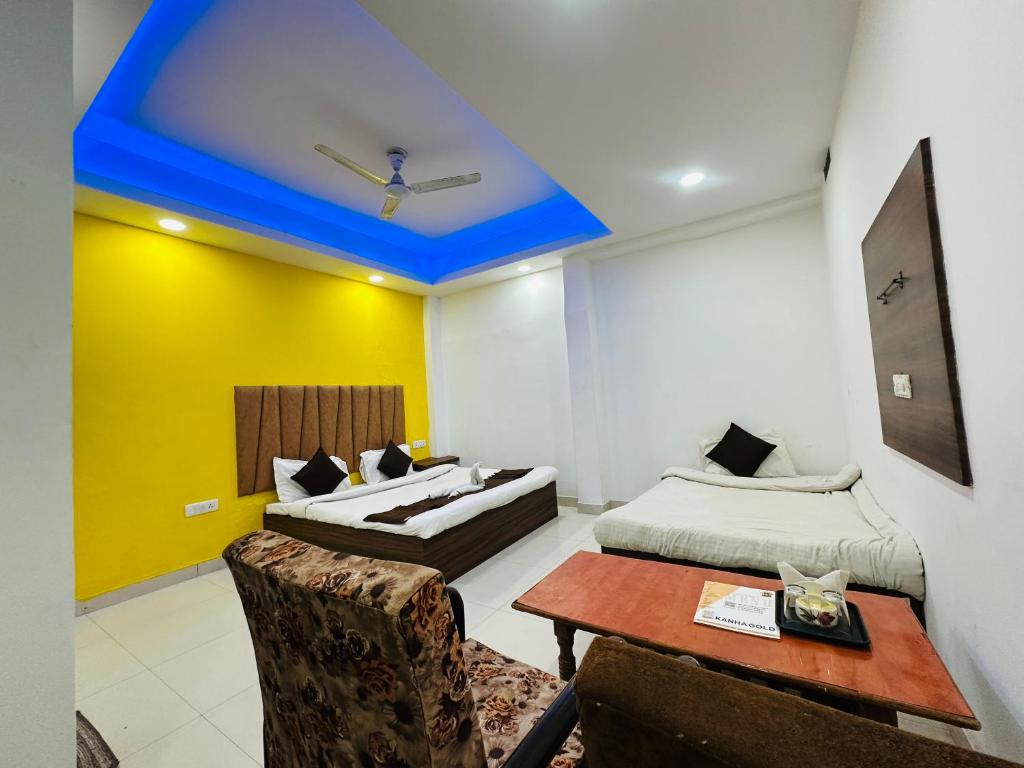 a room with two beds and a table and chairs at Kanha Gold in Bhopal