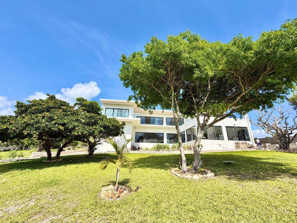 a house with two trees in front of it at Amuji Accommodation and Apartments in Vilanculos