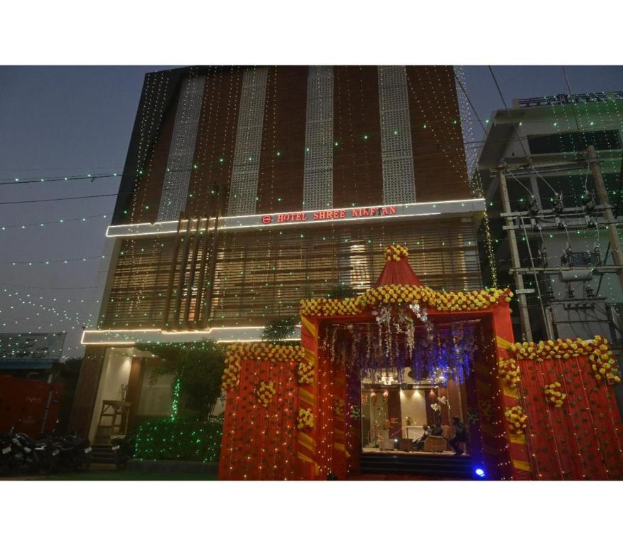 a large building with christmas lights in front of it at Hotel Shree Nikatan in Ara