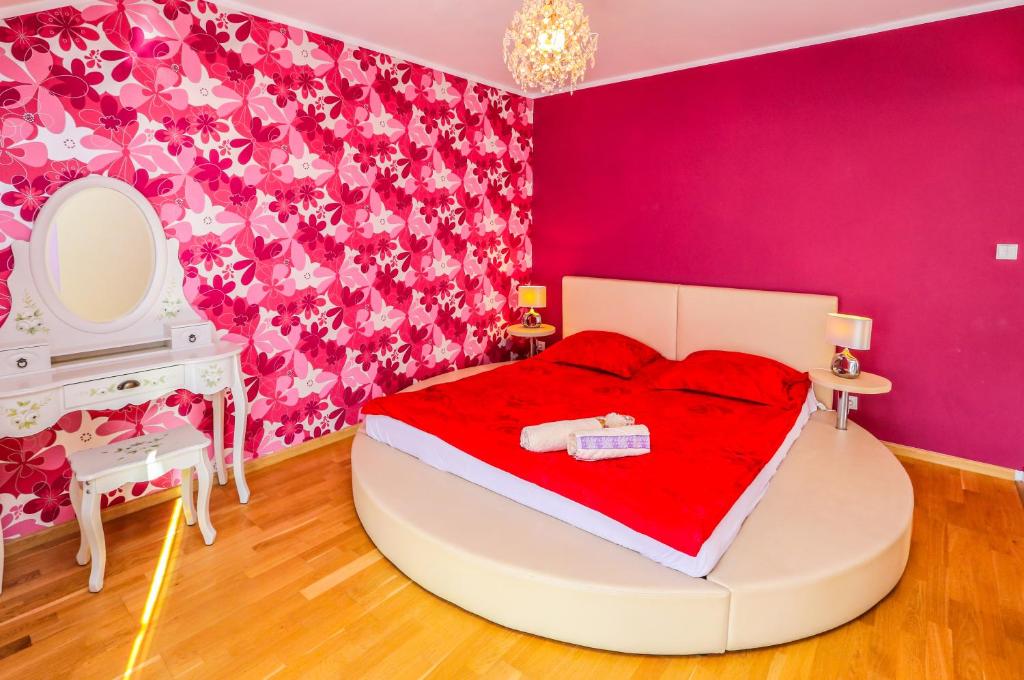 ブワディスワボボにあるApartament Margaritesのピンクのベッドルーム(ベッド1台、鏡付)