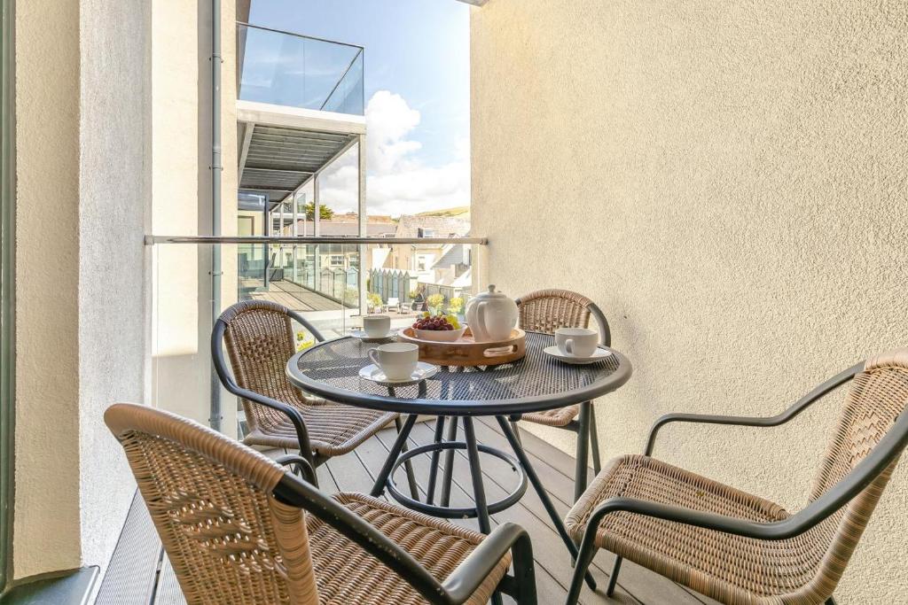 a table on a balcony with chairs and coffee cups at 2 Bed in Woolacombe oc-c29467 in Woolacombe