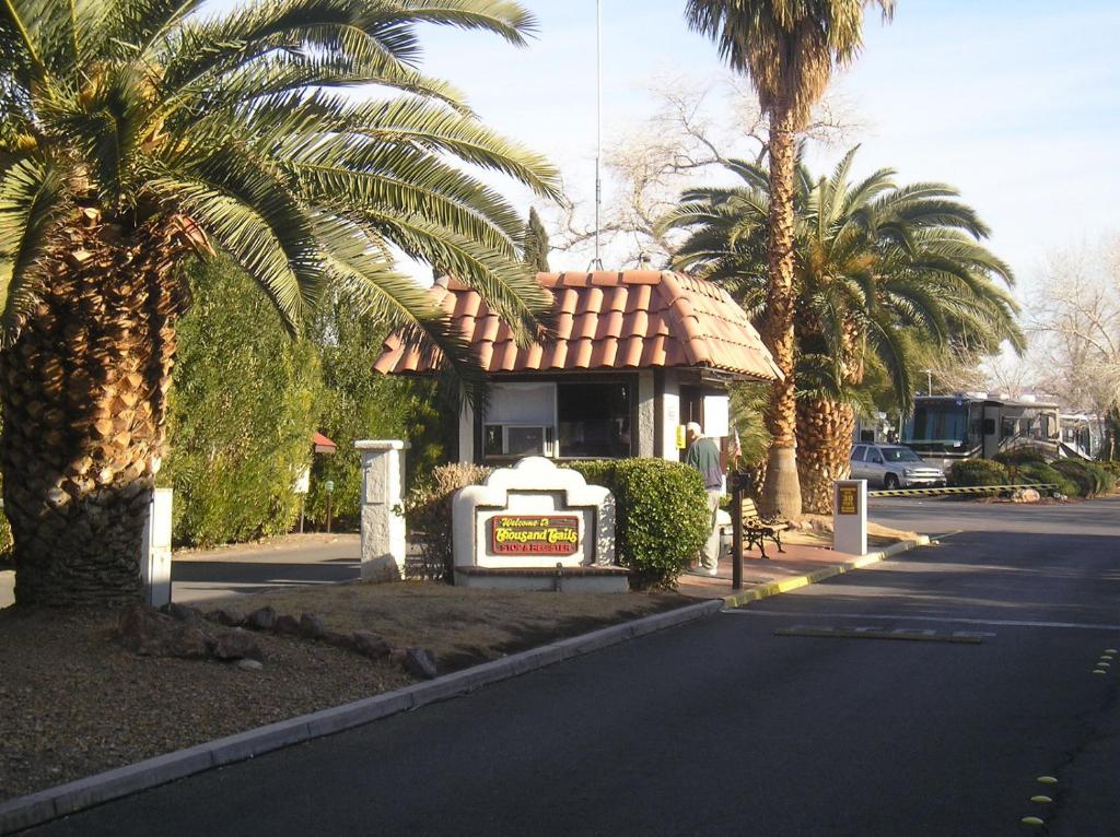 a sign in front of a building with palm trees at Las Vegas Camping Resort Cabin 5 in Las Vegas