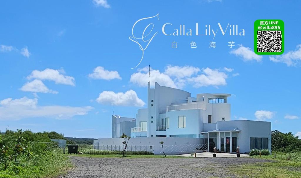 een wit gebouw met een blauwe lucht op de achtergrond bij 白色海芋Villa in Nanwan