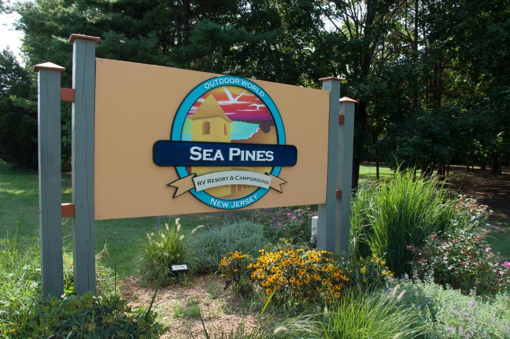 a sign for a sea pines sign in a garden at Sea Pines Loft Park Model 5 in Swainton