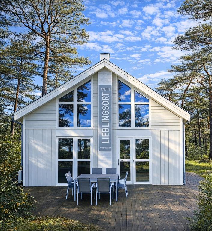 a building with a table and chairs in front of it at Strandhaus Rügen 243 in Baabe