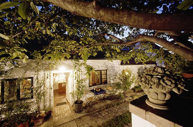 una casa con un árbol delante de ella en Siebenbrüderhof, en Weiden am See