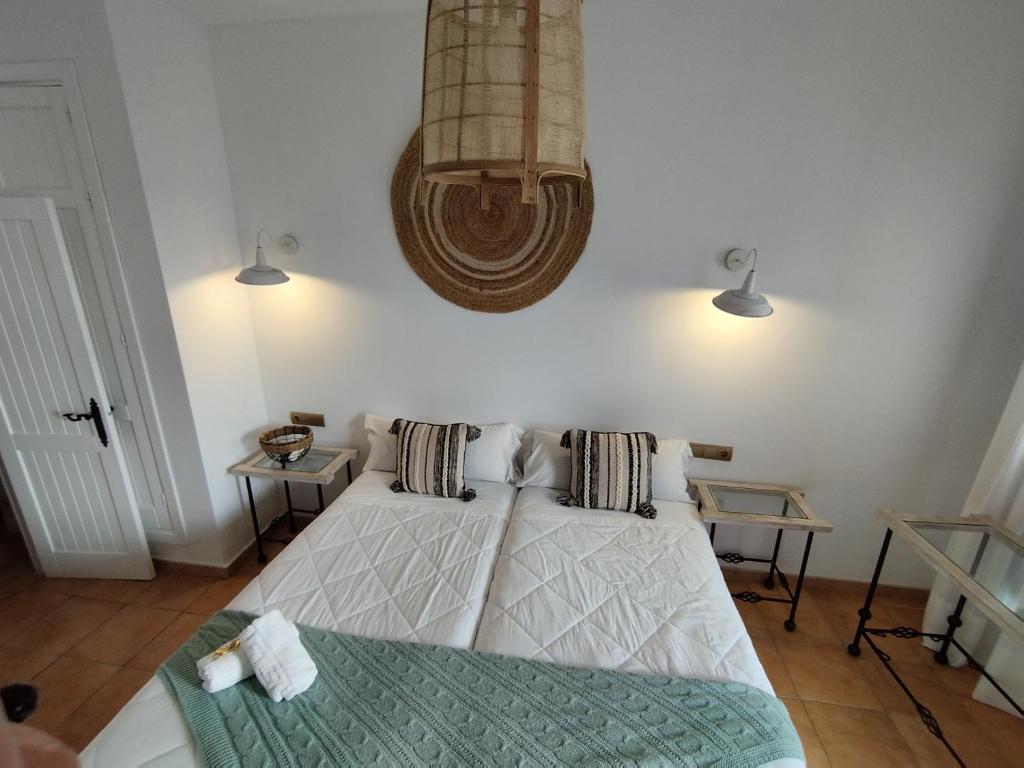 a bedroom with a bed and a chandelier at Hotel Pozo Rey by Youroom in Chipiona