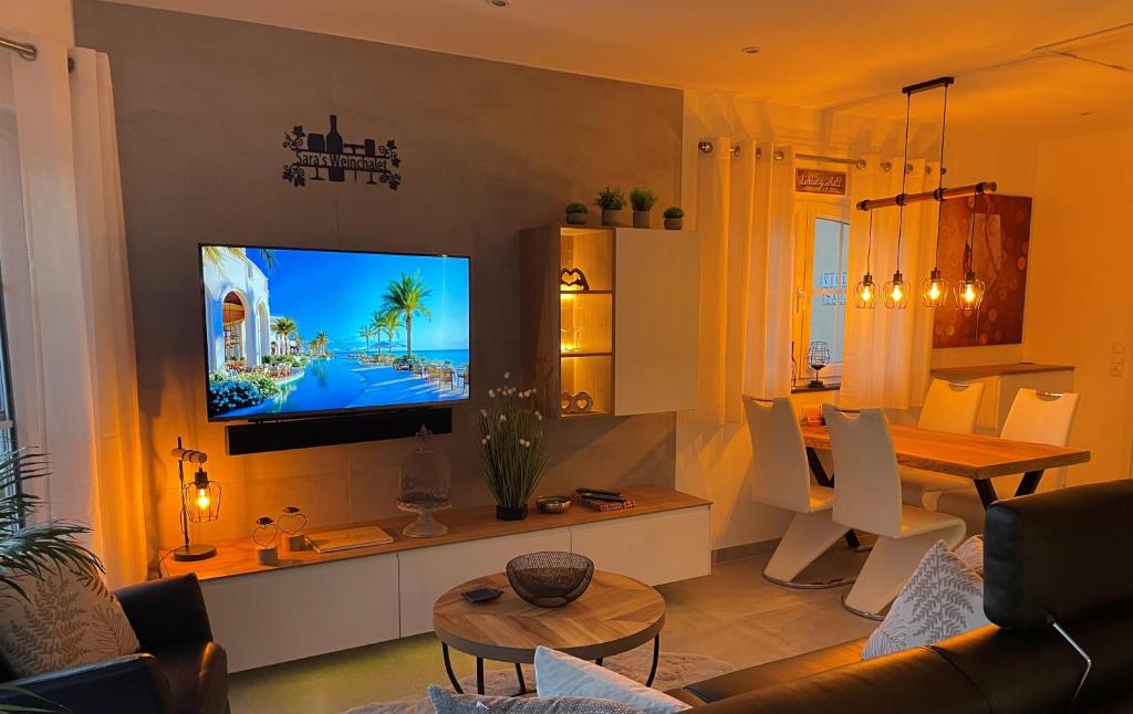 a living room with a television on a wall at Saras Weinchalet in Guntersblum