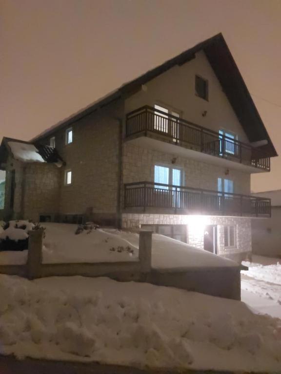 a large building with snow in front of it at Studio apartman KONAK in Kupres