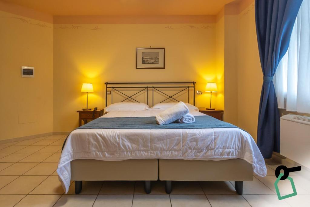 a bedroom with a bed with two towels on it at Hotiday Toscana Riparbella in Riparbella