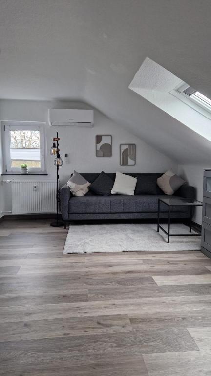 a living room with a black couch in a attic at MaxMir - Ortlohn Apartment Klima in Iserlohn
