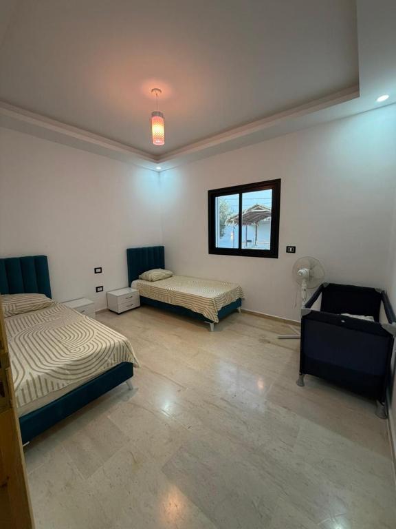 a room with two beds and a window at Montaseur s3 in Al Maqārisah