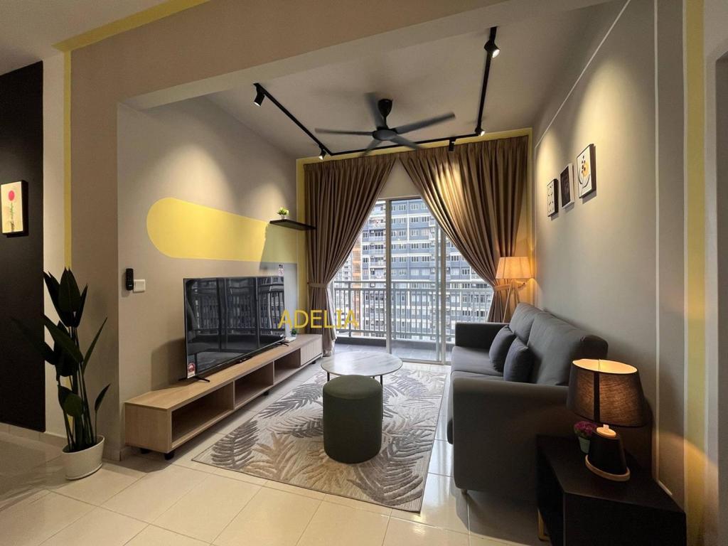 a living room with a couch and a tv at Adelia SweetHome in Kajang