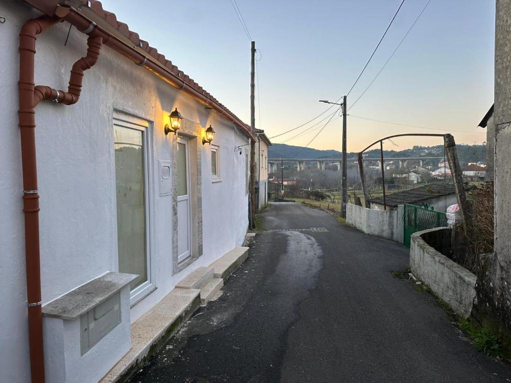 een lege straat naast een wit gebouw bij Refúgio do Ribeirinho in Paredes de Coura