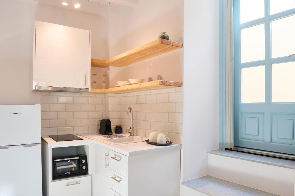 a kitchen with white appliances and a blue door at Galaxidaki στην Πλατεία in Galaxidhion