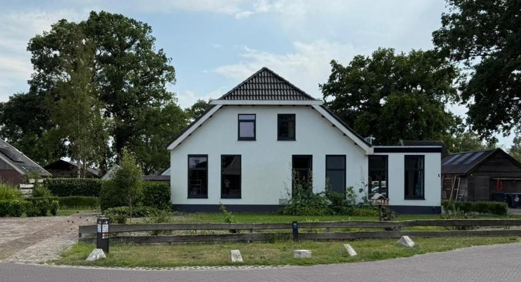 a white house with a black roof at 't Veurhuus in Ansen