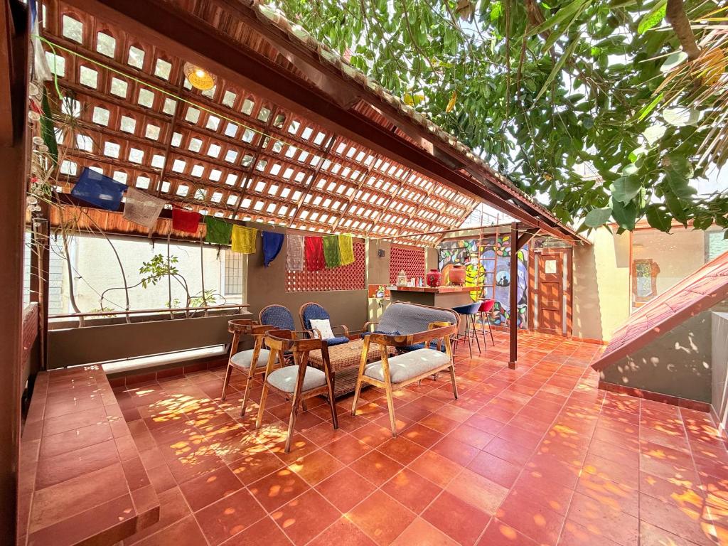een patio met stoelen, een tafel en een aanrecht bij Jugglers Rest Boho Style 4BHK Spacez Luxury Villa with Terrace Lounge in Bangalore