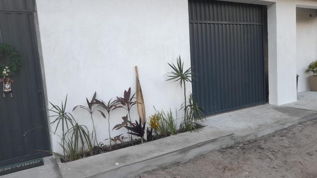 a building with a black gate and some plants at Encantos do Morro in Cayru