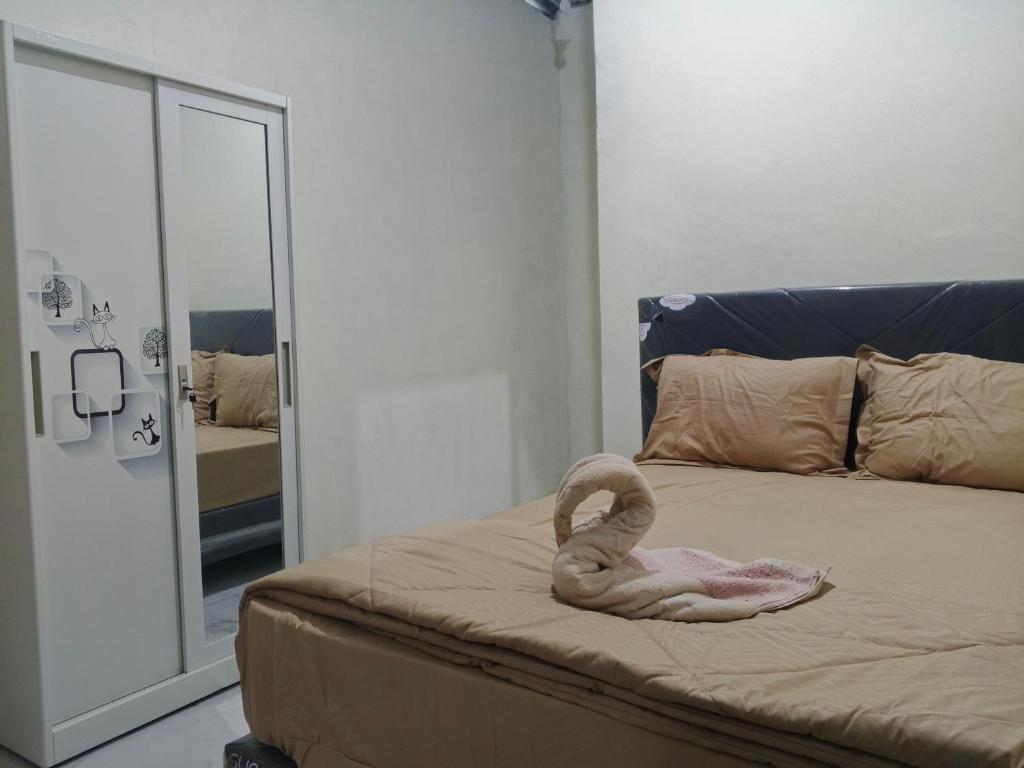 a swan towel on a bed in a room at Sherin Homestay in Pulau Sarang