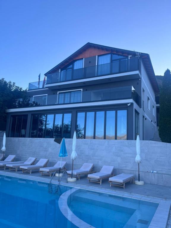 a swimming pool with lounge chairs and a building at Bella Vista Rezidence in Pogradec