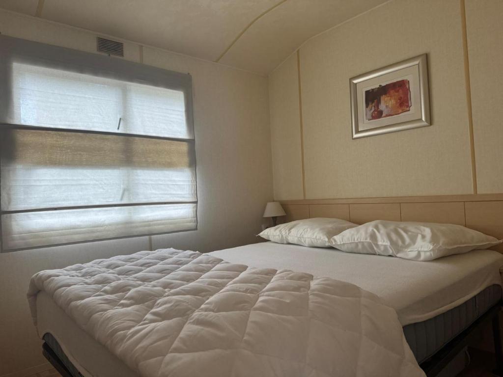 a bedroom with a large bed and a window at Domek na Lazurowym Wybrzeżu in Gassin