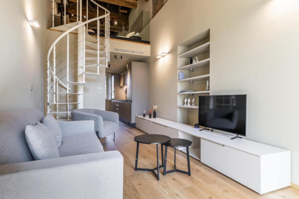 a living room with a couch and a tv at Dimora Beggiami by Vayadù in Savigliano